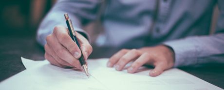 A person using a pen to write on paper.