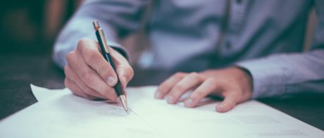 A person using a pen to write on paper.