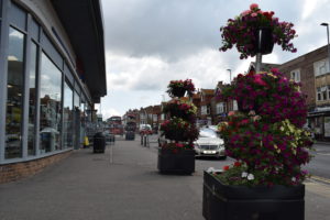 Colourful flowers in pots and hanging baskets in Seaford Town outsite Tescos.