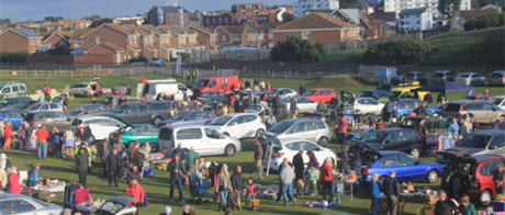 Car boot fayre at Martello Field in Seaford, lots of cars with people walking around.