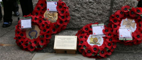 Memorial Stone with poppy wreaths against it.