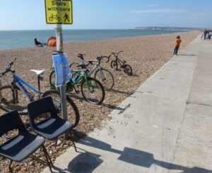 Seaford beach with bicyles on it and part of the promenade.