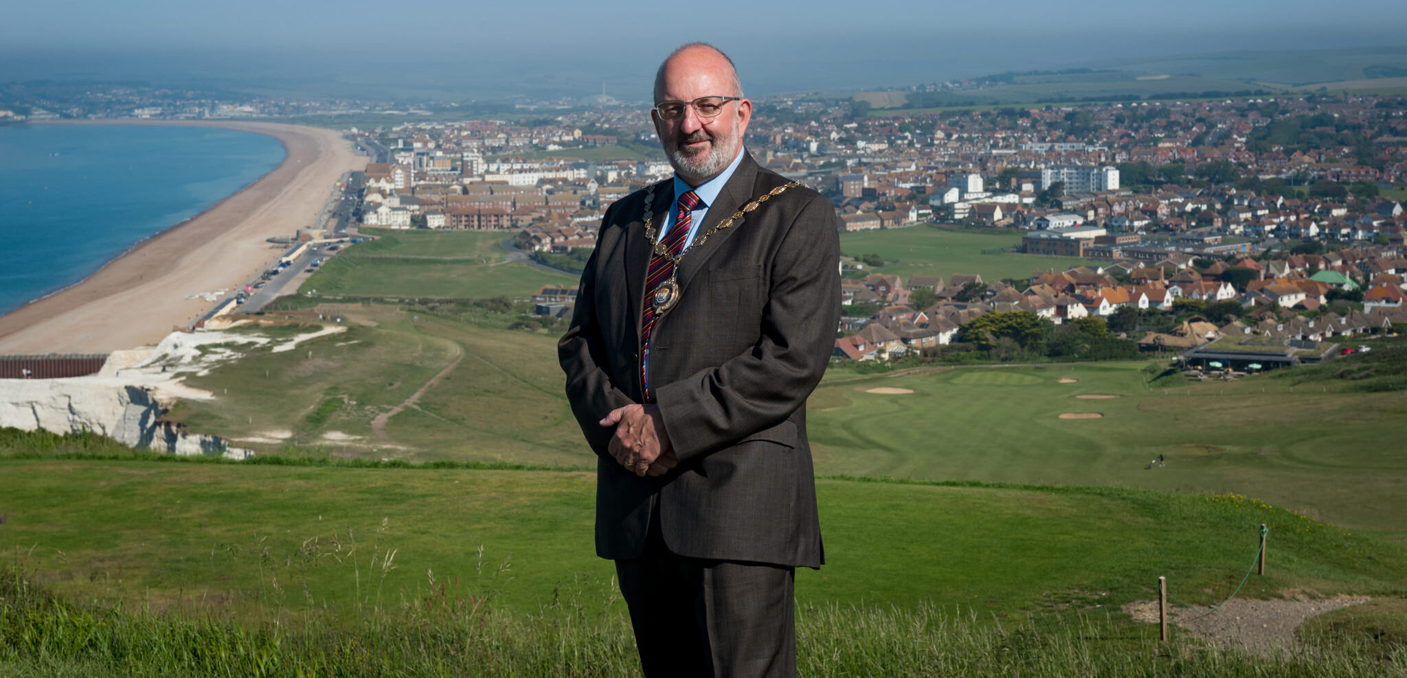 The Mayor of Seaford stands on a hill overlooking the town and beach of Seaford