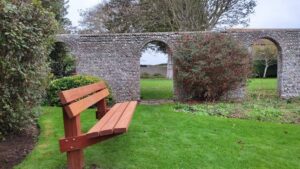 memorial bench in crouch gardens with walled garden behind