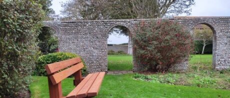 memorial bench in crouch gardens with walled garden behind