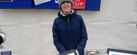 young girl selling items from a market stall