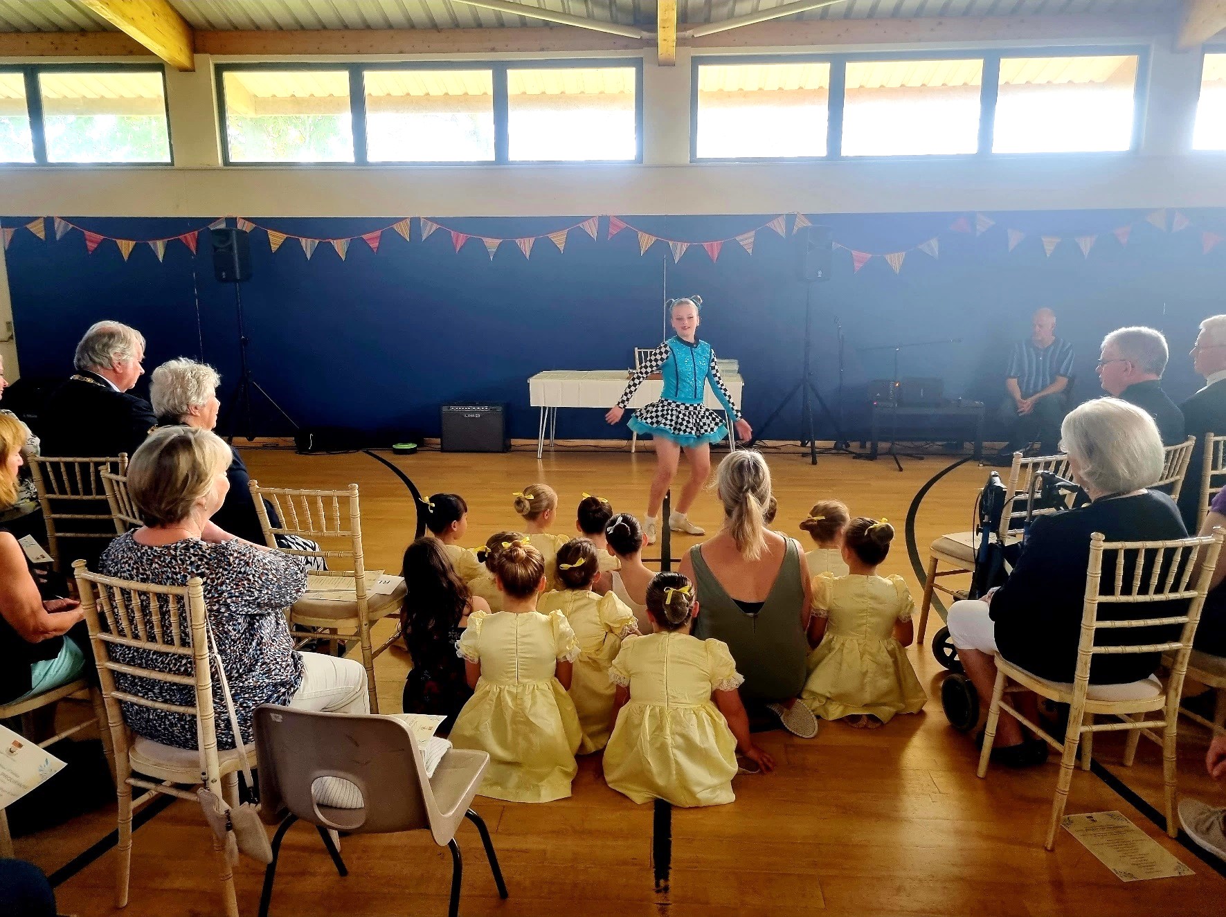 A young tap dancer in a blue sparkly dress