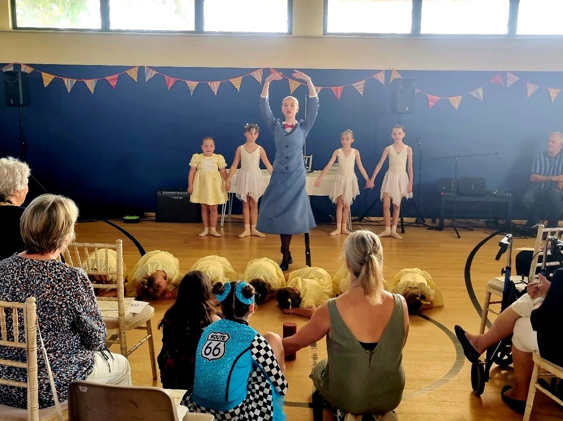 A group of dancers with one lead dancer twirling