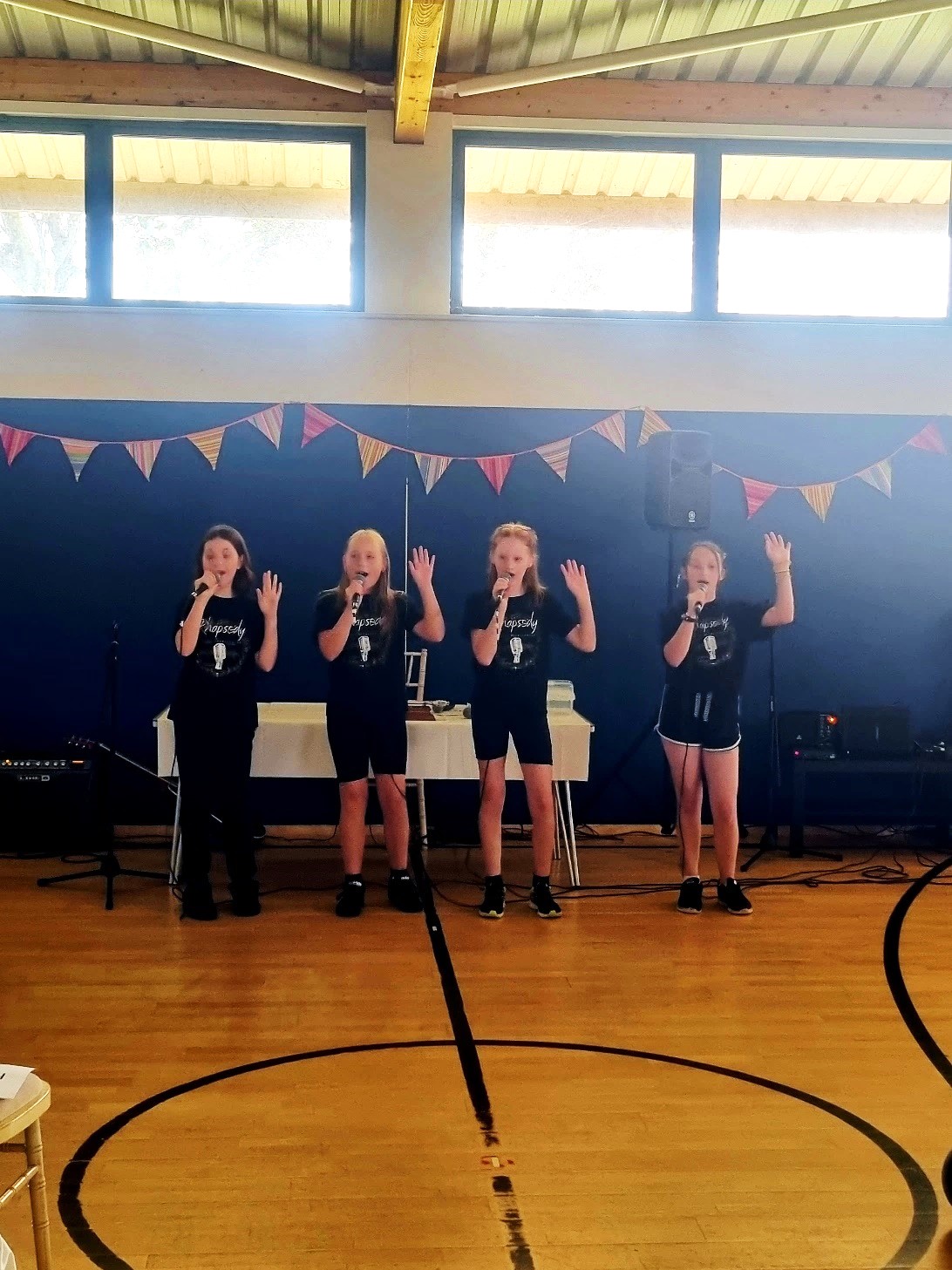 Four young people with microphones singing