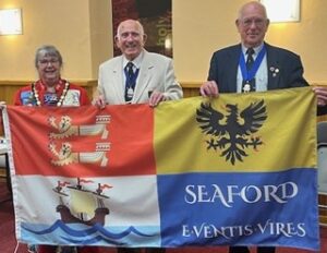 The Mayor and others standing with the flag in front of them.
