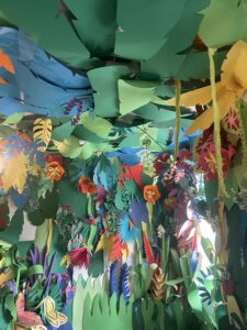 Paper decorations hanging from ceiling to look like a garden. 