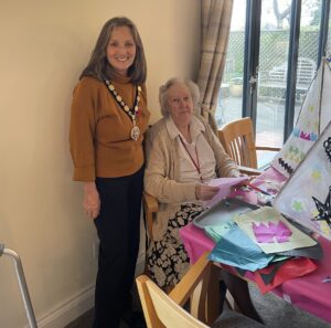 The Mayor will a resident from Nova House decoration a christmas lantern.