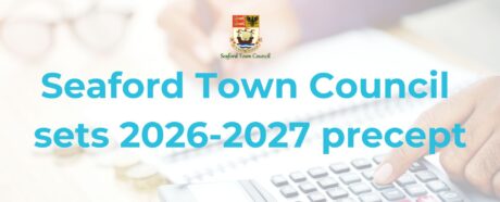 Seaford Town Council sets 2026-2027 precept, with a background of a calculator.