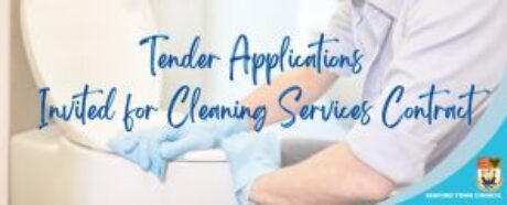 Man wearing blue gloves cleaning a toilet.